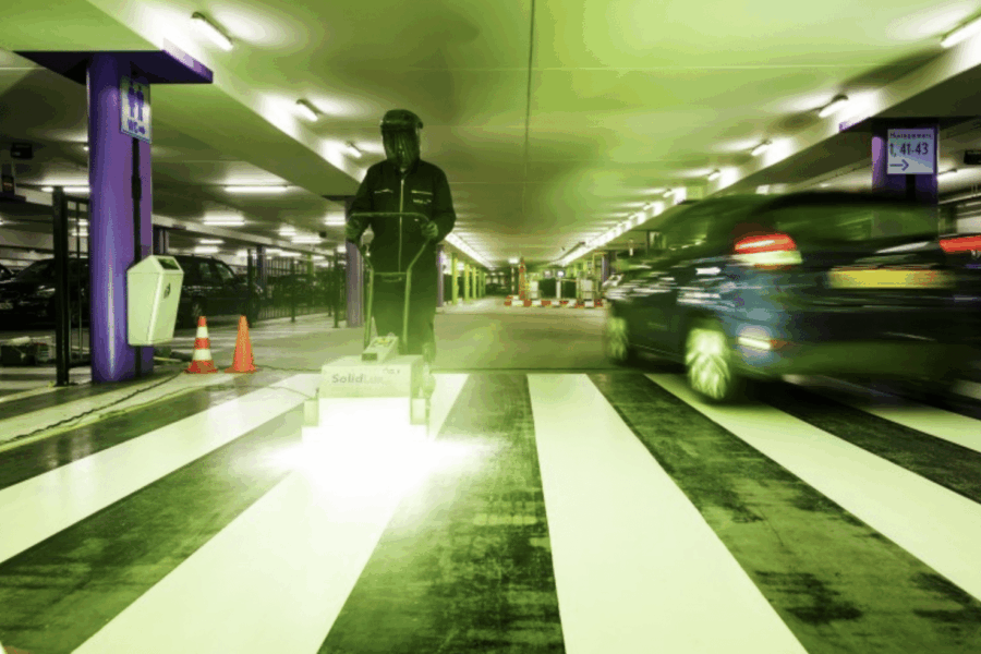 marquage de la peinture UV en bandes blanches pour un passage piétons dans un parking intérieur